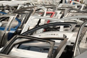 A variety of car doors in different colors arranged in a junkyard setting. - Photo by Aziz Er on Pexels