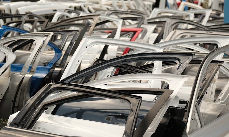 A variety of car doors in different colors arranged in a junkyard setting. - Photo by Aziz Er on Pexels