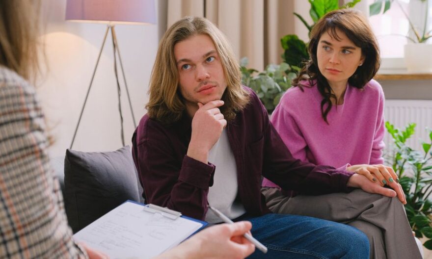A couple holding hands during a therapy session in an office setting. - Photo by SHVETS production on Pexels