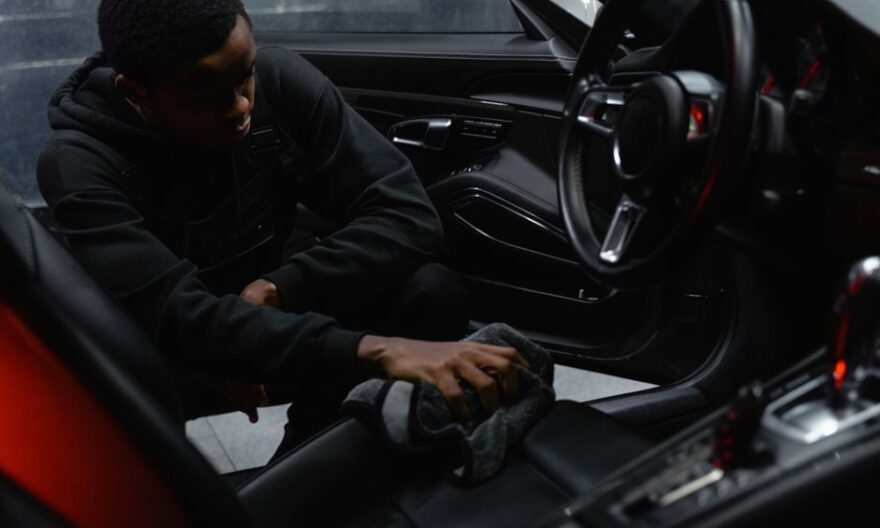 A man wipes the interior of a car for a thorough cleaning, focusing on detailing and maintenance. - Photo by Tima Miroshnichenko on Pexels