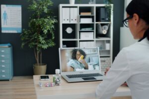 Healthcare professional having virtual appointment with patient on laptop. - Photo by Vitaly Gariev on Pexels